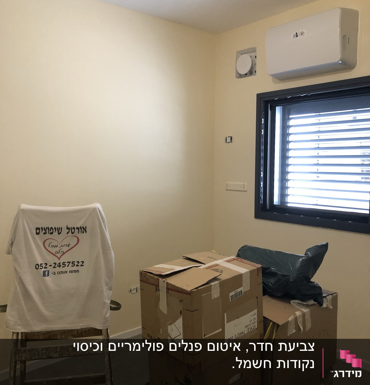 חדר צבוע בצבע בהיר עם סולם וקרטונים